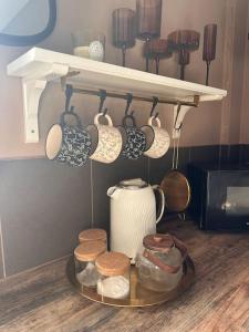 a tray with cups and utensils on a shelf at Everythings Cosy at Clucas in Ormskirk +16 photos