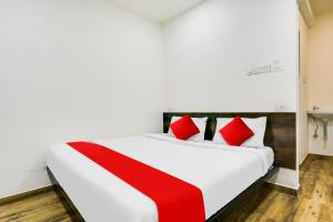 ナーグプルにあるHotel O White Villaの白いベッド(赤い枕付)