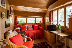 a living room with a red couch in a tiny house at Alp Sunrise - Top View Cozy Chalet in Rougemont