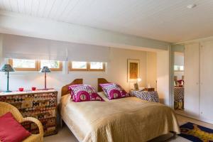 a bedroom with a large bed with pink pillows at Alp Sunrise - Top View Cozy Chalet in Rougemont