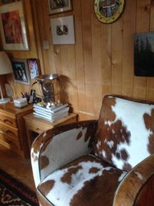 an old chair in a room with a wooden wall at Alp Sunrise - Top View Cozy Chalet in Rougemont +37 photos