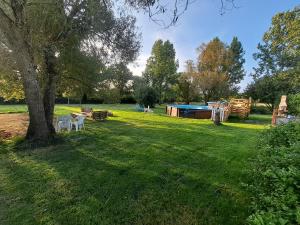 a yard with a picnic table and a tree at Gites de la Janais in Le Pin