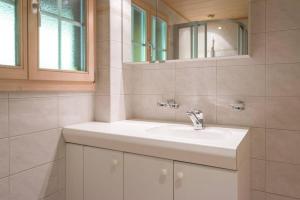 Ένα μπάνιο στο Gstaad Duplex Flat - Amazing Lake Chalet with pond