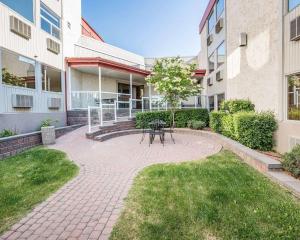 eine Terrasse mit einem Tisch im Innenhof eines Gebäudes in der Unterkunft Quality Inn & Conference Centre in Red Deer