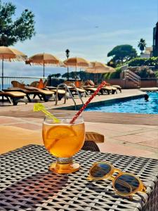 a drink sitting on a table next to a pool at Rigat Park & Spa Hotel - Adults Recommended in Lloret de Mar