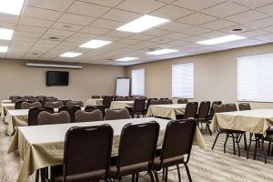 a conference room with tables and chairs and a screen at MainStay Suites Fargo - I-94 Medical Center in Fargo +41 photos