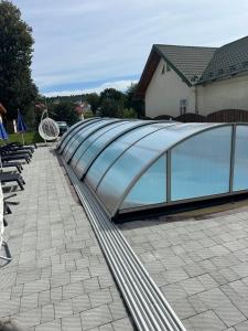 a swimming pool with a glass roof on a patio at Гармонія in Skhidnitsa