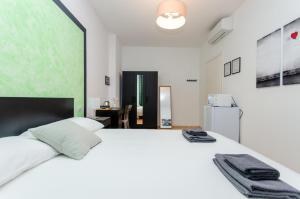 ミラノにあるGreen Roomの緑の壁のベッドルーム1室(白い大型ベッド1台付)