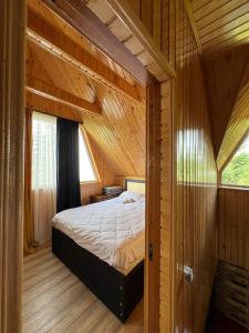 a bedroom with a bed in a wooden cabin at Panorama Gomismta in Gomi