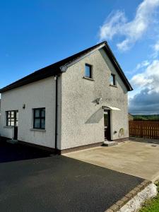 a white brick house with a driveway at Marions Place in Finvoy