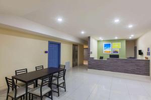 a dining room with a table and chairs at Days Inn by Wyndham Baton Rouge Airport in Baton Rouge