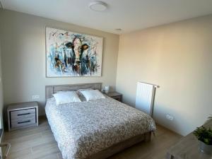 a bedroom with a bed and a painting on the wall at Residentie Sluispark in Ghent