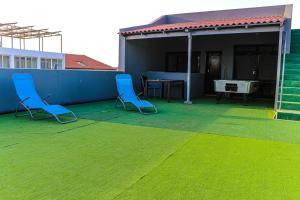 - deux chaises bleues sur une terrasse avec une table dans l'établissement Coração de Santa Maria, à Santa Maria
