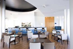 a restaurant with tables and chairs and a bar at TRYP by Wyndham Porto Expo Hotel in Leça da Palmeira