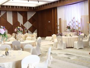 a banquet hall with white tables and chairs and flowers at Swissotel Living Jeddah in Jeddah +118 photos