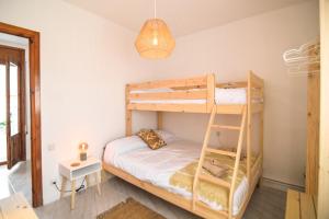 una camera con 2 letti a castello e una lampada di Descubre Somontano a Torres de Alcanadre Altre 32 foto