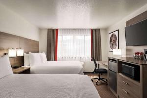 a hotel room with two beds and a desk at Best Western Helena - Capitol Hotel in Helena