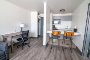 an apartment with a kitchen and a desk and chairs at Best Western Helena - Capitol Hotel in Helena