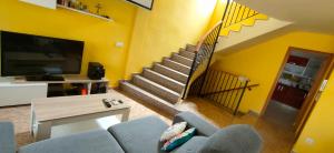 a living room with a couch and a staircase at Casa Mediterrània in Xeraco