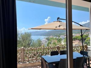 a table with a umbrella and a view of the water at Appartamento Blue in Cala Gonone