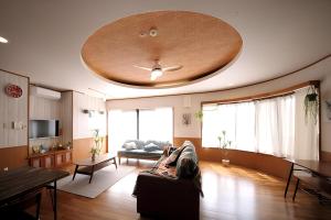 a person laying on a couch in a living room at UmisoraHouseうみそらはうす石垣島グループ宿泊施設 in Ishigaki Island