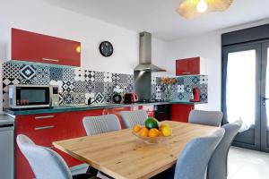 eine Küche mit einem Holztisch mit einer Obstschale darauf in der Unterkunft Duplex Bellevue - Entre Mer et Montagne - Meublé Classé 3 Etoiles in Le Tampon