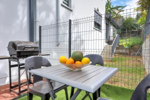 eine Schale Obst auf einem Tisch mit einem Grill in der Unterkunft Duplex Bellevue - Entre Mer et Montagne - Meublé Classé 3 Etoiles in Le Tampon + 15 Fotos