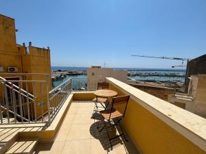 un balcone con due sedie e un tavolo su un edificio di Le Casette del Porto di Sciacca a Sciacca