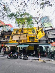 deux motocycles garés devant un bâtiment jaune dans l'établissement IL Divo Hostel & Spa 61 Bát Sứ, à Hanoï