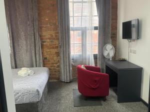 a bedroom with a bed and a chair and a window at Kick back relax stylish space in Nottingham