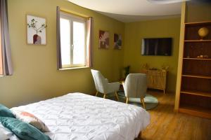 a bedroom with a bed and two chairs and a table at rêve nature in Calais