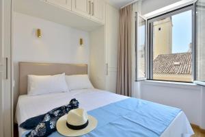una camera con un letto con un cappello e una finestra di Fill In Luxury Apartment, Corfu Old Town a Città di Corfù