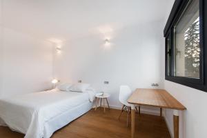 a bedroom with a bed and a table and a window at Villa O2 Mallorca - by EMERALD STAY in Cielo de Bonaire  +18 photos