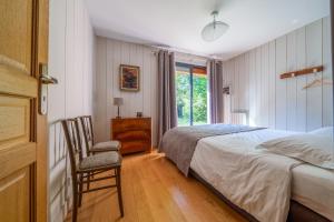 une chambre avec un lit, une chaise et une fenêtre dans l'établissement La cabane du pont du Douet, à Mazières-de-Touraine