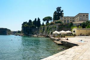 una spiaggia con persone che nuotano nell'acqua di Fill In Luxury Apartment, Corfu Old Town a Città di Corfù