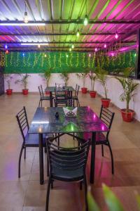 a dining room with tables and chairs and lights at Hotel Dream Inn in Mānglia