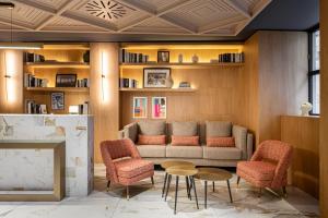 ein Wohnzimmer mit einer Couch und Stühlen und einem Tisch in der Unterkunft Room Mate Leo, Granada in Granada