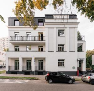 a black car parked in front of a white building at Willa Wincent in Gdynia