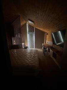a dark room with a piano and a window at Alma Lake in Băluţoaia