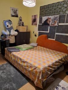 a bedroom with a bed with a teddy bear on the wall at Chambre avec lit 2 personnes in Ville-en-Sallaz