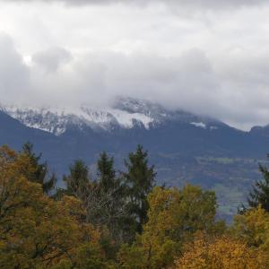 a snow covered mountain obscured by clouds and trees at Chambre avec lit 2 personnes in Ville-en-Sallaz +1 photo