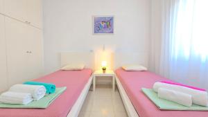 two beds in a room with pink and green sheets at CSS Cute Superior King's Palace in Paphos City +13 photos