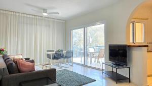 a living room with a couch and a television at CSS Cute Superior King's Palace in Paphos City