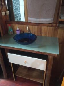 a bathroom counter with a blue sink on it at Chalé 2 pinheiros in Urubici