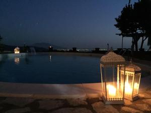 eine Laterne mit Lichtern neben einem Swimmingpool bei Nacht in der Unterkunft Hotel Ristorante Guardanapoli in Cervino