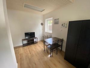 ein Wohnzimmer mit Tisch und Stühlen und einem Fernseher in der Unterkunft Kleever Apartment Bad Schwalbach in Bad Schwalbach