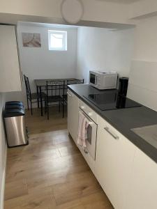 eine Küche mit einer Mikrowelle und einem Tisch mit Stühlen in der Unterkunft Kleever Apartment Bad Schwalbach in Bad Schwalbach + 20 Fotos