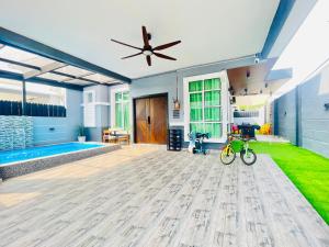 a living room with a ceiling fan and a bike on the floor at Resthouse Asyura in Malacca