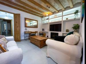 a living room with two white couches and a tv at Apartment Rafol in Vilanova i la Geltrú