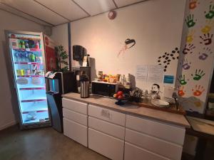 a kitchen with a counter and a refrigerator at SKAP Hostel Mandal in Mandal
